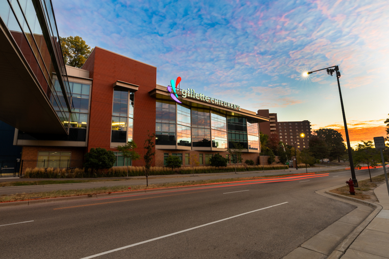 Modern building with reflective glass windows under a colorful sky.