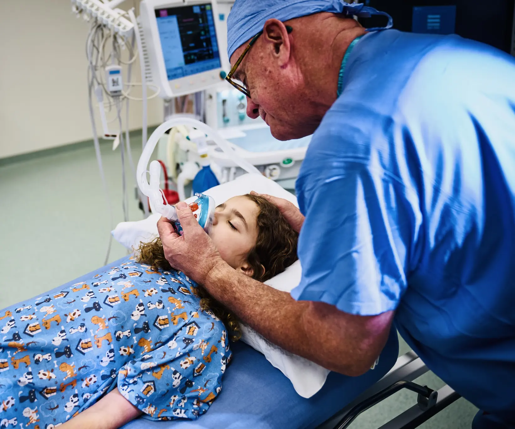 Doctor tending to a child patient in a hospital bed.