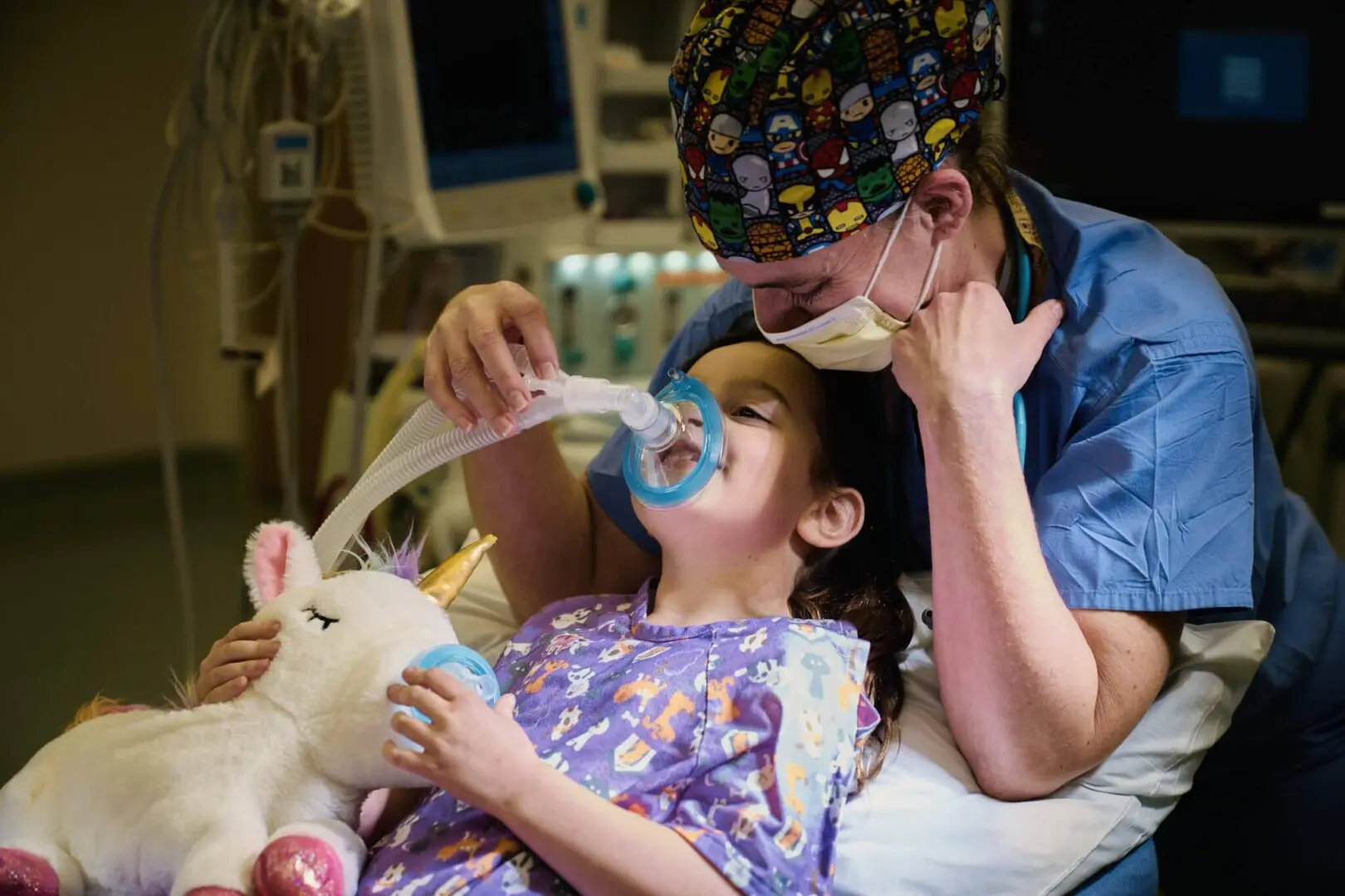 A nurse comforting a child patient with an oxygen mask in a hospital.