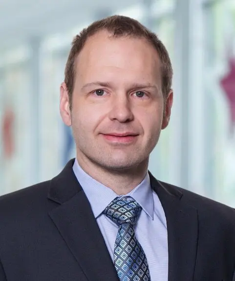 Professional man in a suit and tie with a blurred background.