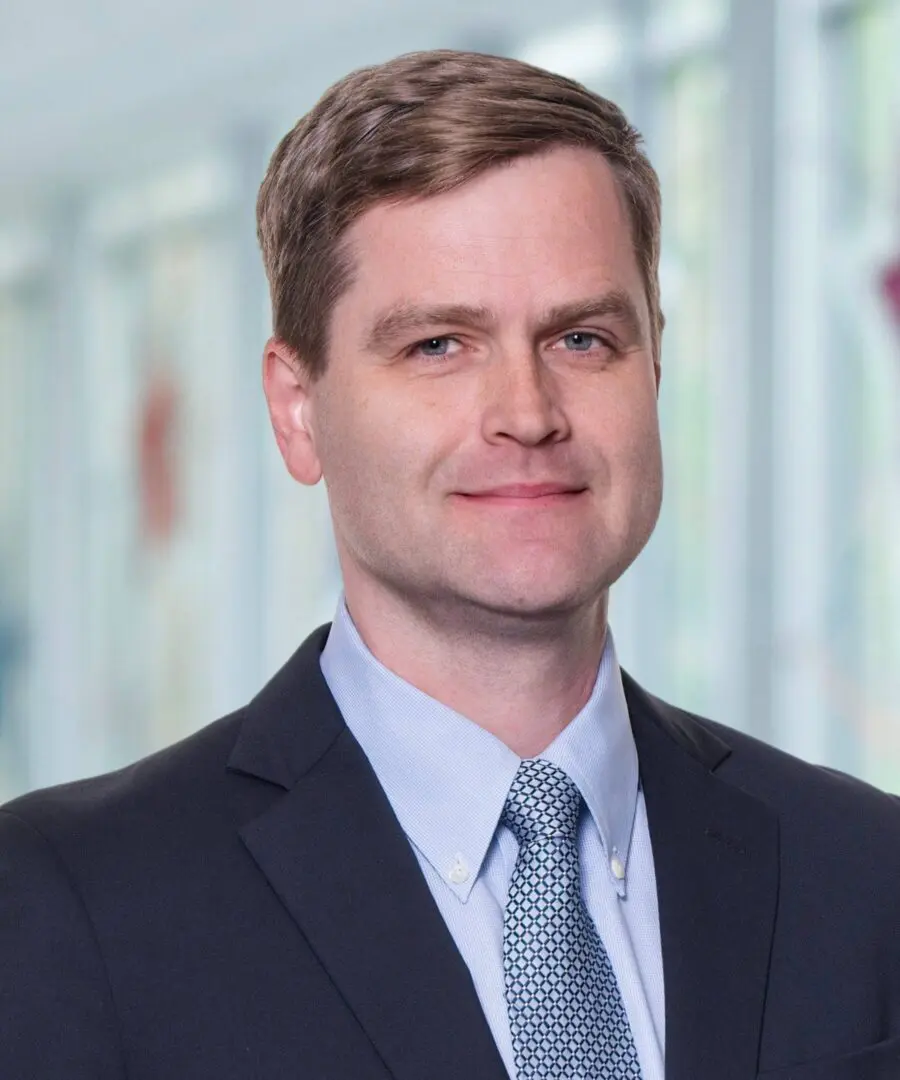 Man in suit with blurred background.