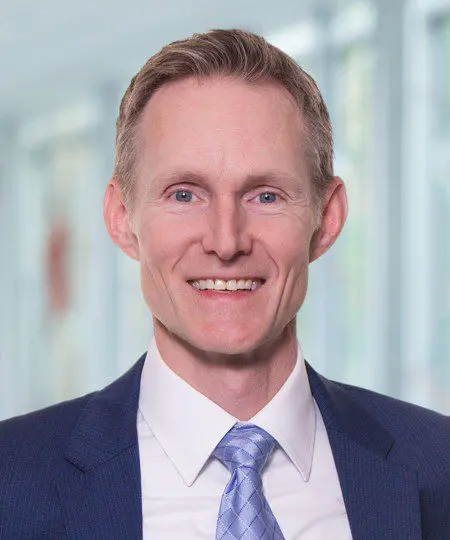 Professional man in a suit smiling at the camera.