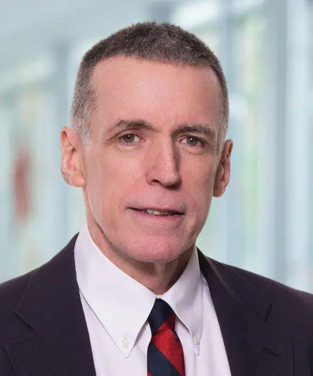 Professional headshot of a middle-aged man in a suit and tie.