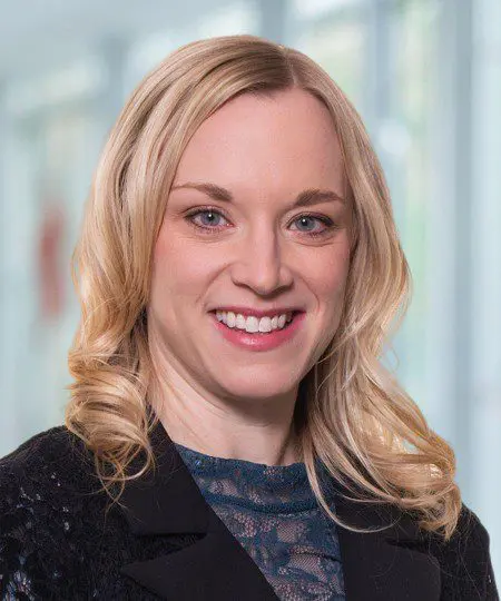 Smiling woman with blonde hair in a professional setting.