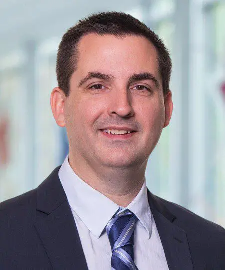 Professional man in suit smiling indoors.