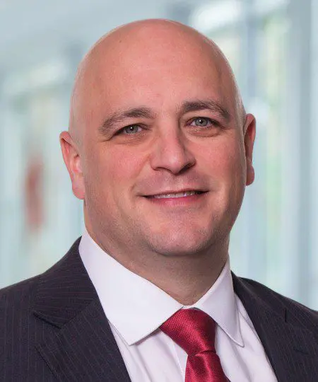 Professional man in suit and red tie smiling.