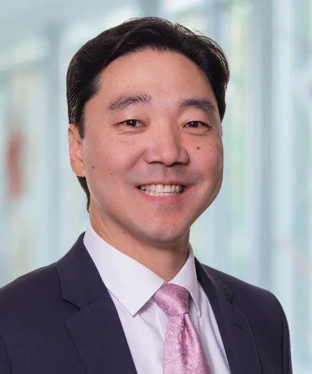 Professional man in a suit smiling indoors.