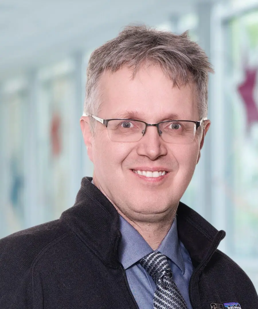 Smiling man with glasses and tie